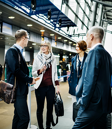 Meeting fellow business associates at airport terminal in the midst of travel